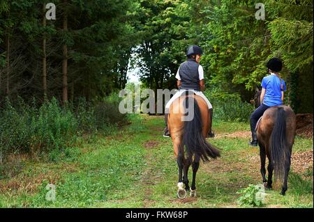 Rear view of mature woman and girl horse riding Stock Photo