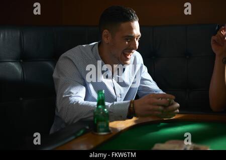 Man shuffling playing cards at pub card table Stock Photo