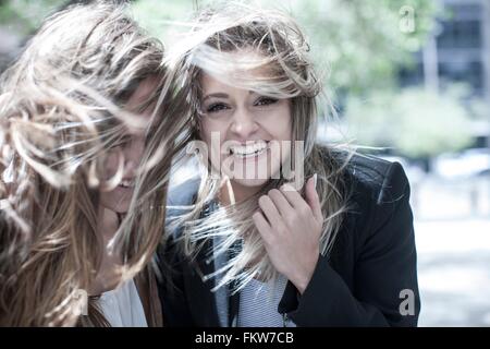 Portrait of young woman and teenage girl with flyaway hair in city Stock Photo