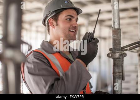 Builder using walkie talkie on construction site Stock Photo