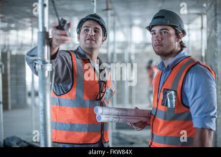 Site manager and builder pointing on construction site Stock Photo
