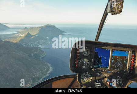 Aerial view from a helicopter cockpit flying over Cape town. Interior of helicopter cockpit with instruments panel. Stock Photo