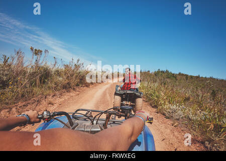 Young man on quad bike. Young man driving all terrain vehicle in nature. View from a ATV. Stock Photo