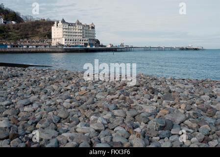 The Grand Hotel and Llandudno Pier photographed from the pebble beach on the seafront at Llandudno North Wales Great Britain UK Stock Photo