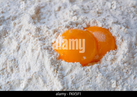 Two egg yolks on flour. Close view. Stock Photo