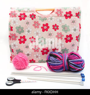 Pink flower patterned knitting / craft bag with knitting needles, pink and multi colour wool and scissors on a white background. Stock Photo