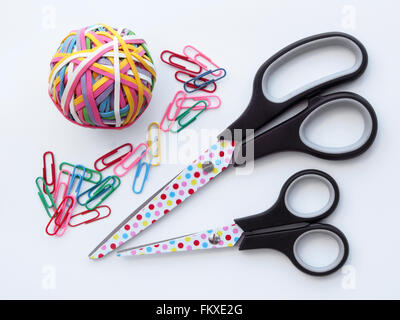 Collection of stationery, scissors, paperclips and elastic bands on a white background. Stock Photo