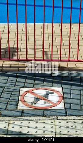 No dogs sign on the paved floor of a childrens playground area on a new build housing estate. Bicester, Oxfordshire England Stock Photo