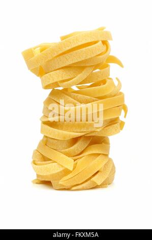 Stack of tagliatelle pasta nests over a white background Stock Photo