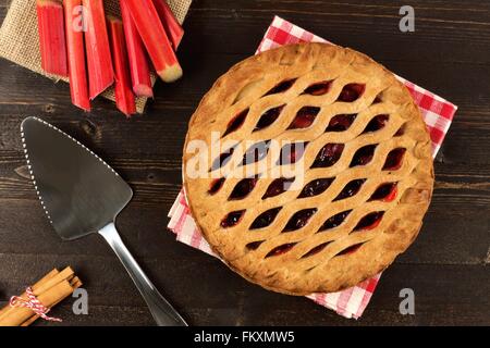 Sweet strawberry and rhubarb pie overhead scene on a dark wooden background Stock Photo