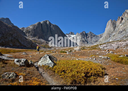 WYOMING - Hiker stopping to take a picture in the Upper Titcomb Basin area of Wind River Range in the Bridger Wilderness. Stock Photo