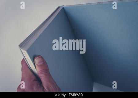 hand holding open book with blank pages Stock Photo