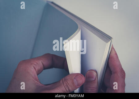 hands turning pages in empty book with blank pages Stock Photo