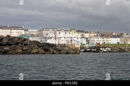 Entrance to Portrush harbour with houses and guest-house in the town of Portrush in the background, in County Antrim, Northern Ireland Stock Photo