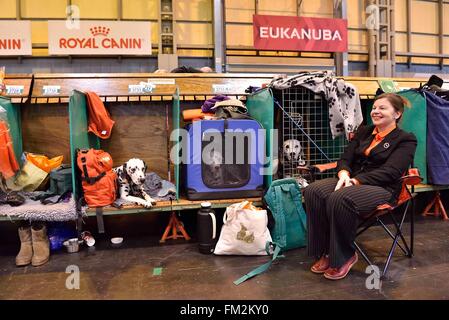 Birmingham, Britain. 10th Mar, 2016. A woman sits with her dogs at the Crufts Dog Show in Birmingham, Britain, March 10, 2016. The annual four-day event, opened on Thursday, is one of the largest in the world. Credit:  Ray Tang/Xinhua/Alamy Live News Stock Photo