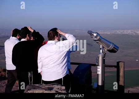 Israeli orthodox Jews admire the Syrian side of Quneitra area from an Israeli military stronghold which was built on an older Syrian stronghold which is now an attraction point for visitors in the strategic peak of mount Bental a dormant volcano in the Golan heights northern Israel Stock Photo