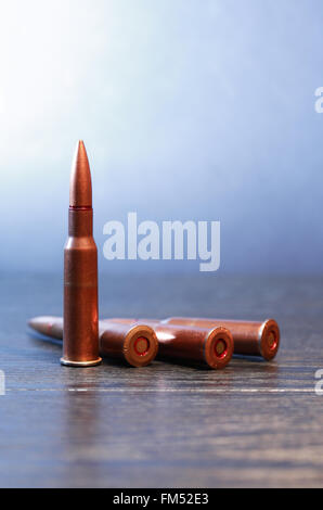 Single unfired 7.62mm bullet and brass casing lying diagonal on an