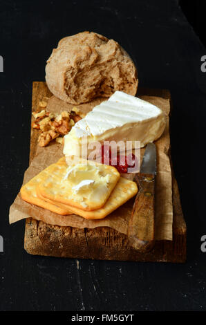 cheese and crackers on old wooden board Stock Photo