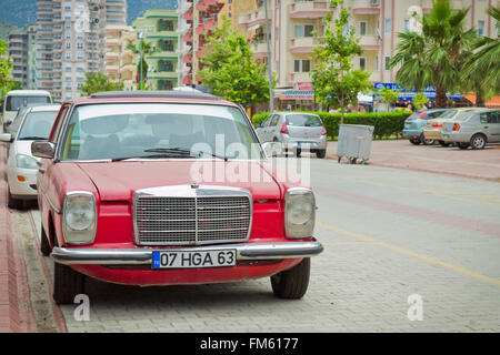 KEMER, TURKEY - MAY, 2013: Old Mercedes on the street of the village of Kemer in Turkey. Old red car parked on the roadside Stock Photo