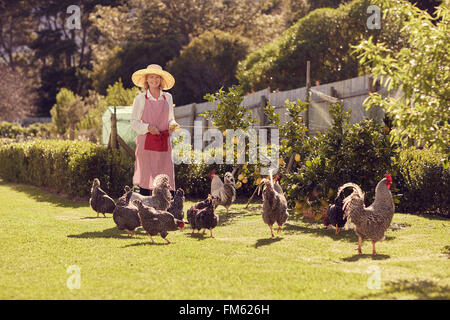 Senior woman in her backyard with free range chickens Stock Photo