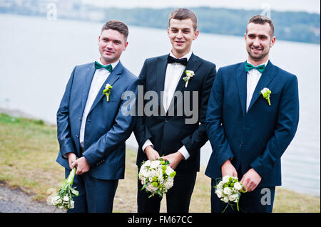 Three friends, groom with groomsman having fun, male potency theme Stock Photo