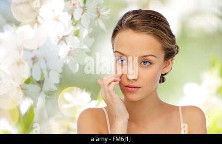 young woman applying cream to her face Stock Photo