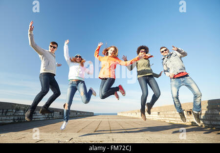 smiling friends in sunglasses laughing on street Stock Photo