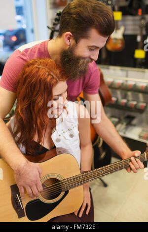couple of musicians with guitar at music store Stock Photo