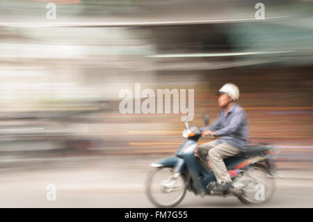 A moped travelling through Hanoi, Vietnam Stock Photo