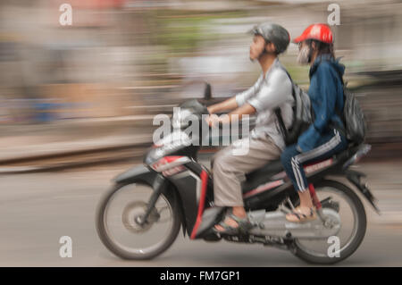 A moped travelling through Hanoi, Vietnam Stock Photo