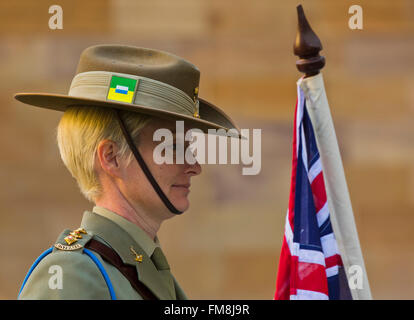 uniformed female australian army officer soldier on parade holding flag on Anzac day at anzac square, brisbane, australia Stock Photo