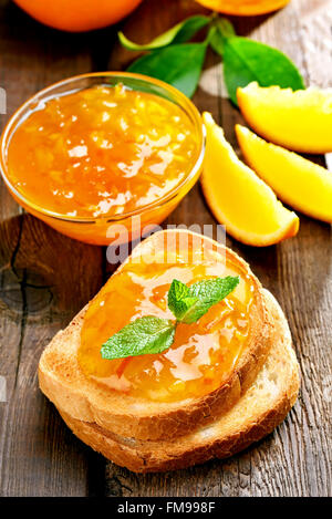 Orange jam on toast over wooden table Stock Photo
