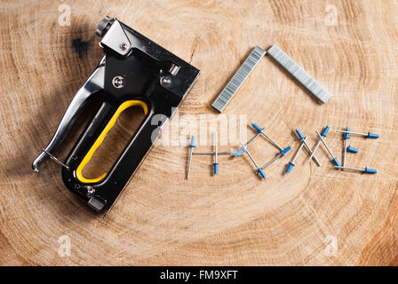 construction stapler on wooden background and text Stock Photo