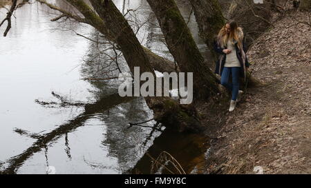 The girl in the early spring, the water sits on the river bank Stock ...