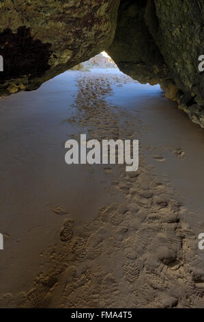 Exploring a cave in Albandeira beach, Lagoa, Algarve, Portugal Stock Photo