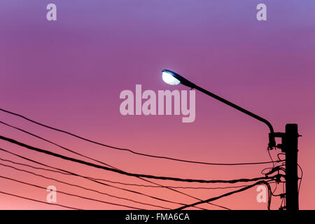 Street light pole with cable line against twilight sky background Stock Photo