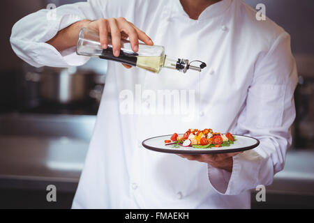 Chef putting finishing touch on salad Stock Photo