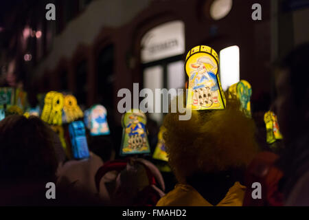 A group with illuminated head lanterns waits during the Basel carnival 2016 for the switching off of lights on Monday morning. Stock Photo
