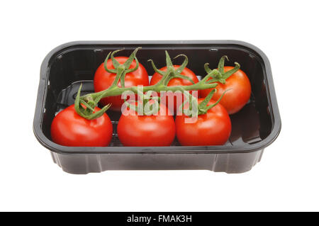 Vine ripened tomatoes in a plastic tray isolated against white Stock Photo