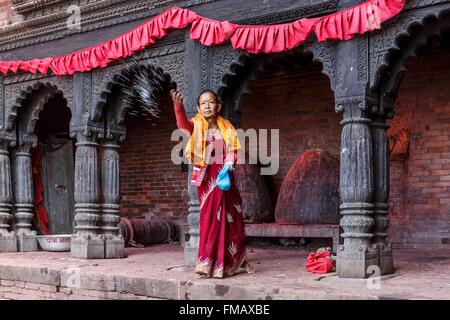 Nepal, Gandaki zone, Gorkha, a woman throwing rice in the Gorkha Durbar Stock Photo