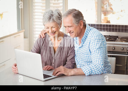 Cheerful senior couple using laptop Stock Photo