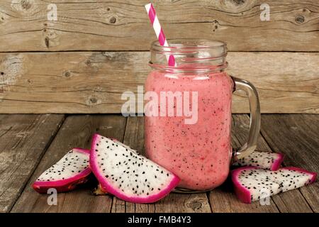 Pink raspberry, dragon fruit smoothie with fruit slices on an old wood background Stock Photo