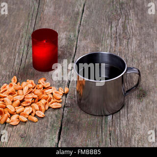 coffee, the burning candle and peanut on a table Stock Photo