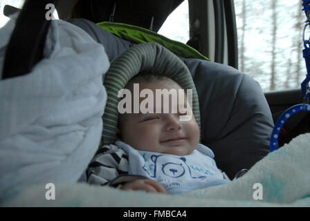 A baby dreaming in a car seat Stock Photo