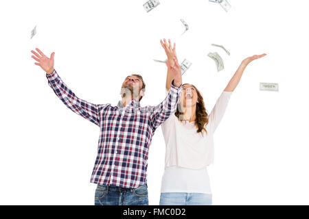 Happy young couple throwing currency notes in air Stock Photo