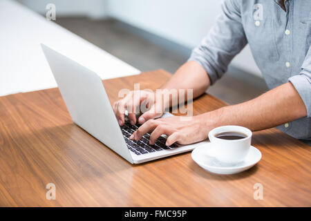 Midsection of man working on laptop Stock Photo
