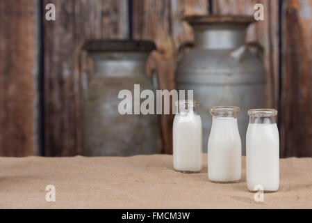 Three old bottles of milk lined up on right side. Empty space on left Stock Photo