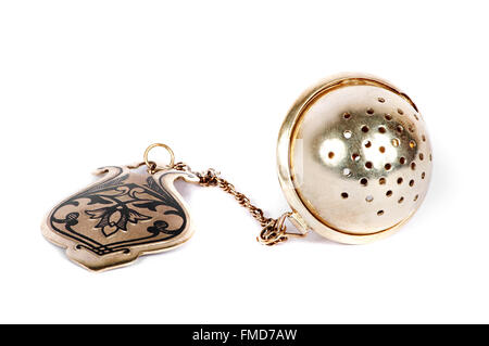 Old silver tea-strainer on a white background Stock Photo