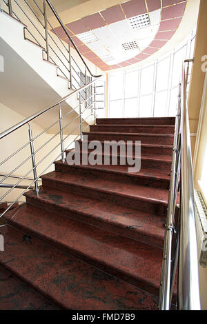 Marble staircase with a steel handrail in a modern building Stock Photo