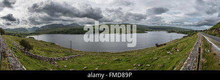 The Poisoned Glen (Dunlewy Lough) lies right at the foot of Errigal. The moody clouds fit the name of the lake. Stock Photo